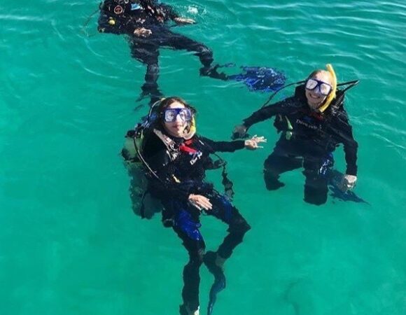Three female divers floating in Red Sea about to start diving