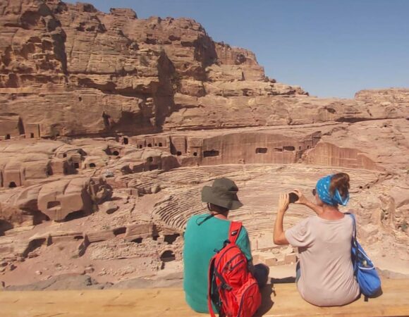 A couple is making a picture sitting opposite the Theatre in Petra Jordan