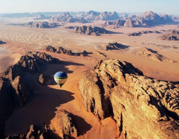 Hot air balloon over the Wadi Rum desert huge mountain ridges and cliffs
