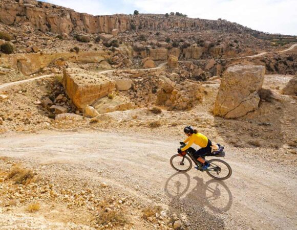 Lady on her mountainbike ccycling from Dana to Petra on a dirt road down hill.