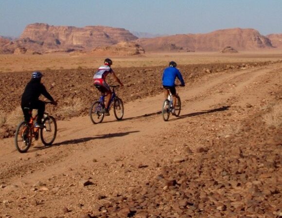 3 people on MTB in Wadi Rum desert with Salma Tours