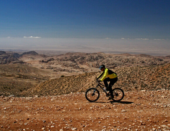 Mountain biker with view on Little Petra mountains