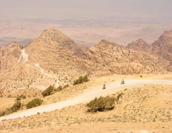 Mountain bikers in Jordan with mountains behind them